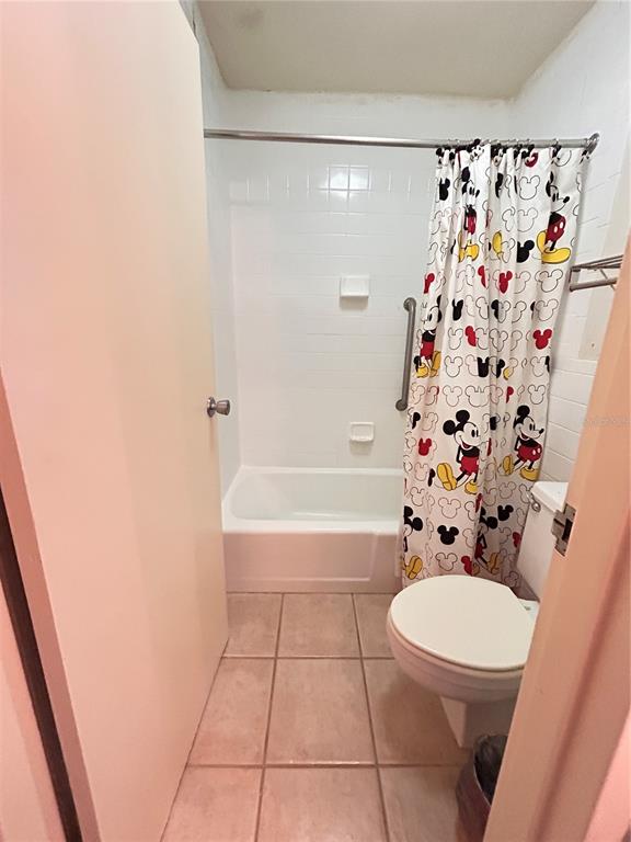 A bathroom features a white bathtub, a toilet, and a Mickey Mouse patterned shower curtain — 43420 HIGHWAY 27 UNIT 455, DAVENPORT, FL