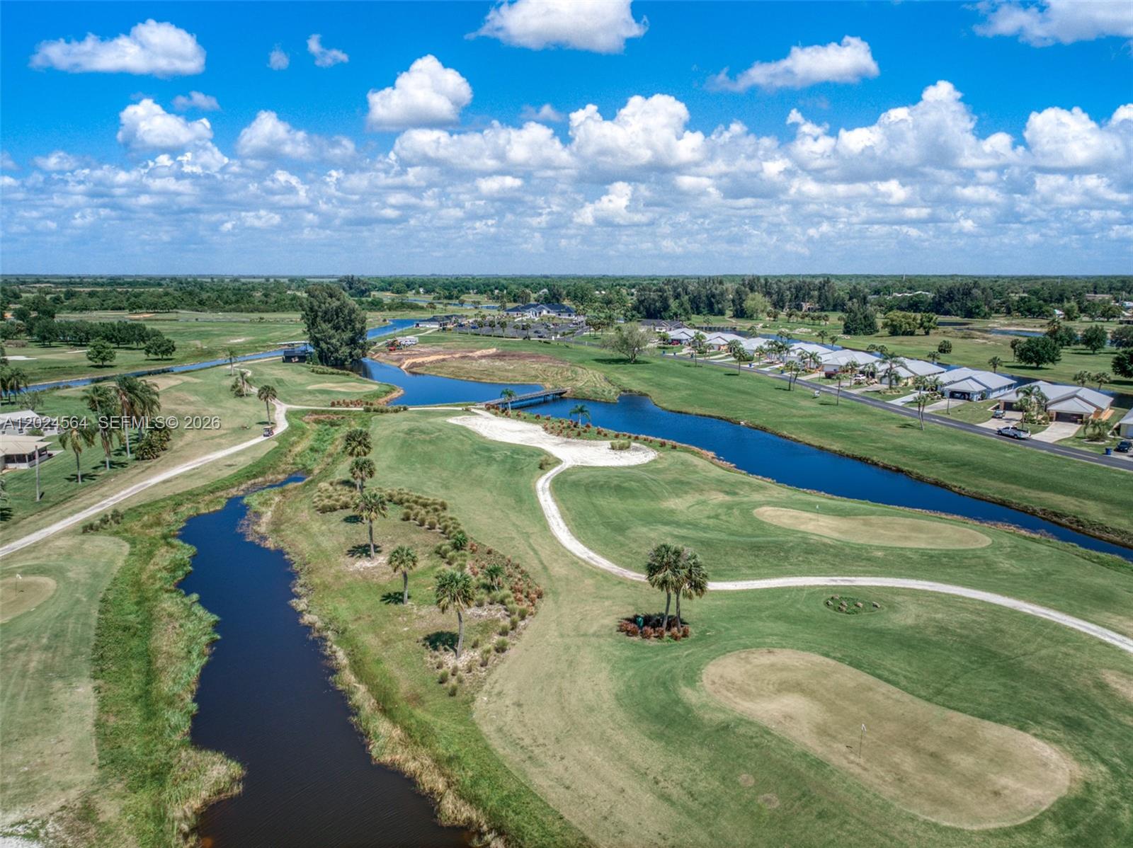 An aerial view shows a golf course with winding paths, water hazards, and nearby residential houses — 6813 Heavitree, Sebring FL 33876, SEBRING, FL