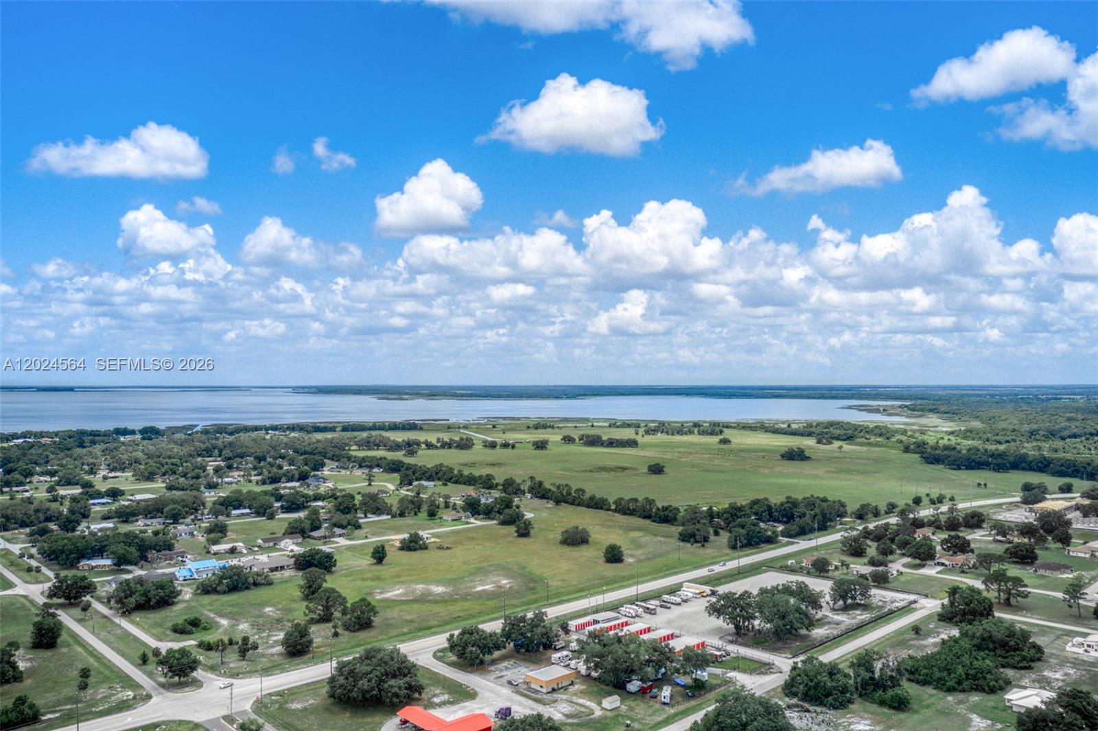An aerial view shows a rural landscape with a large lake, scattered houses, and roads — 6813 Heavitree, Sebring FL 33876, SEBRING, FL