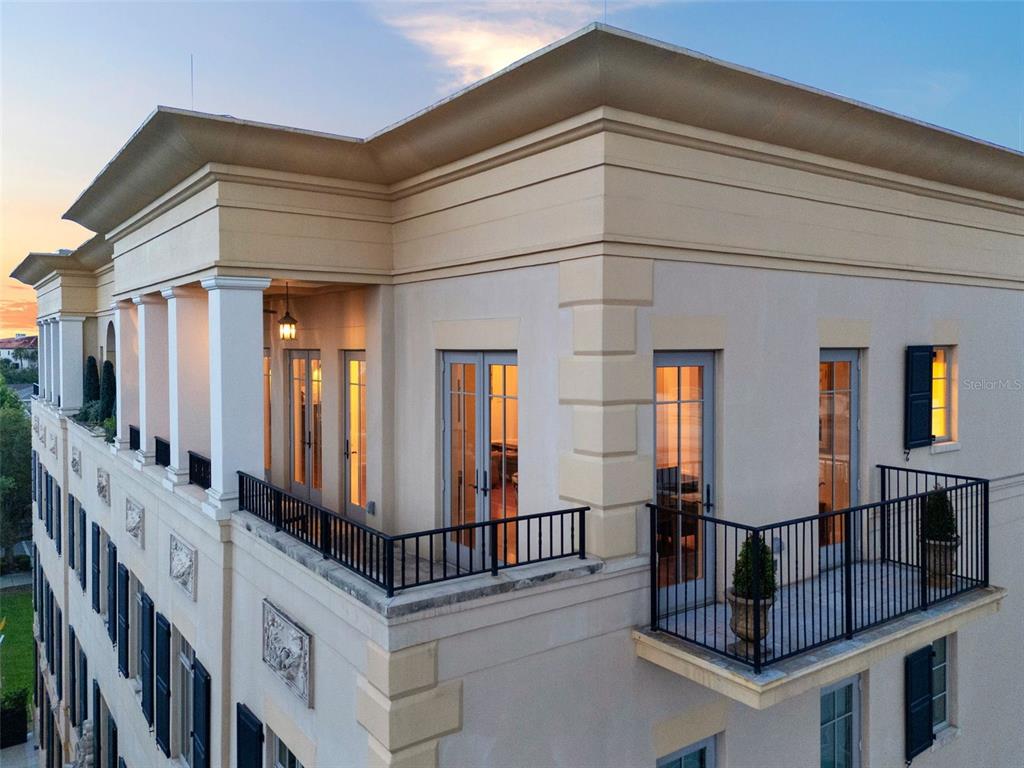 An exterior view of a multi-story building featuring balconies with black railings and columns — 140 E MORSE BOULEVARD UNIT J, WINTER PARK, FL