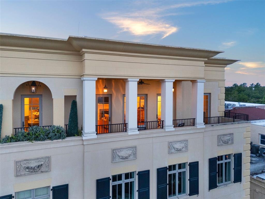 An exterior view of a building featuring a covered balcony with columns and arched windows — 140 E MORSE BOULEVARD UNIT J, WINTER PARK, FL