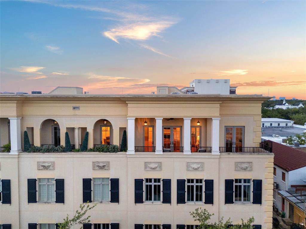 An exterior view of a multi-story building featuring a balcony with columns and shutters — 140 E MORSE BOULEVARD UNIT J, WINTER PARK, FL