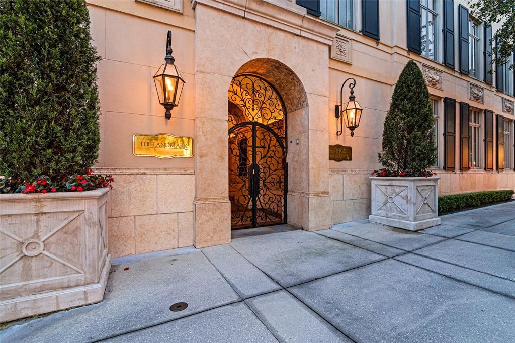 An arched wrought iron gate serves as the entrance to a stone building exterior — 140 E MORSE BOULEVARD UNIT J, WINTER PARK, FL