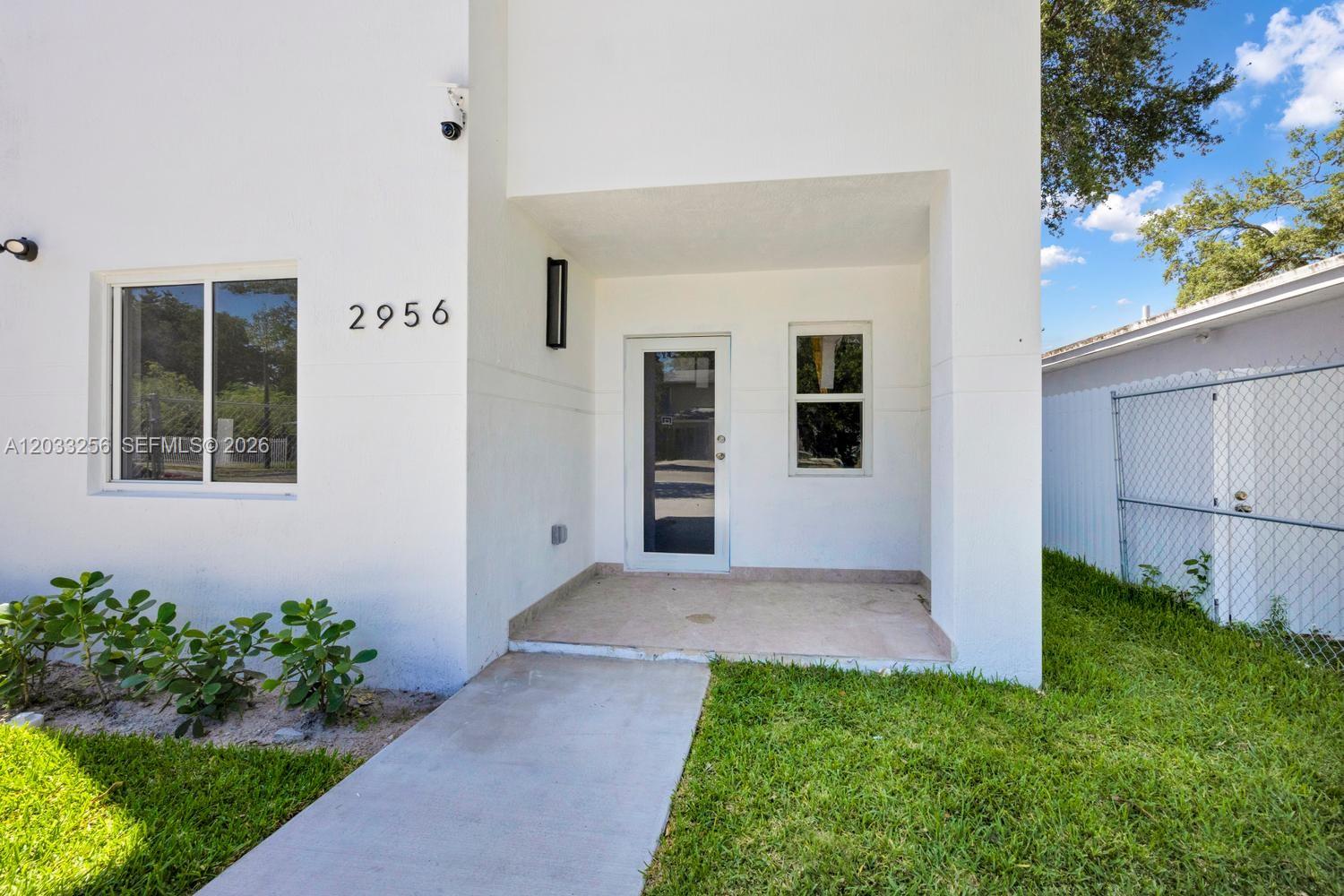 The exterior of a white house features a front entrance, a walkway, and a lawn — 2780 NW 44th St, Miami FL 33142, MIAMI, FL