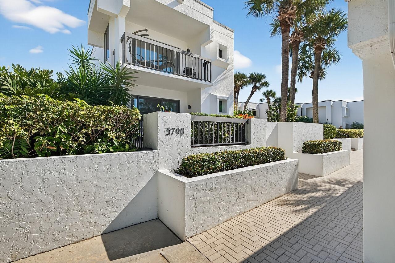 A white two-story building with a balcony and a low wall featuring the number 5790 — 5790 Highway A1a # 2a, Vero Beach FL 32963, VERO BEACH, FL