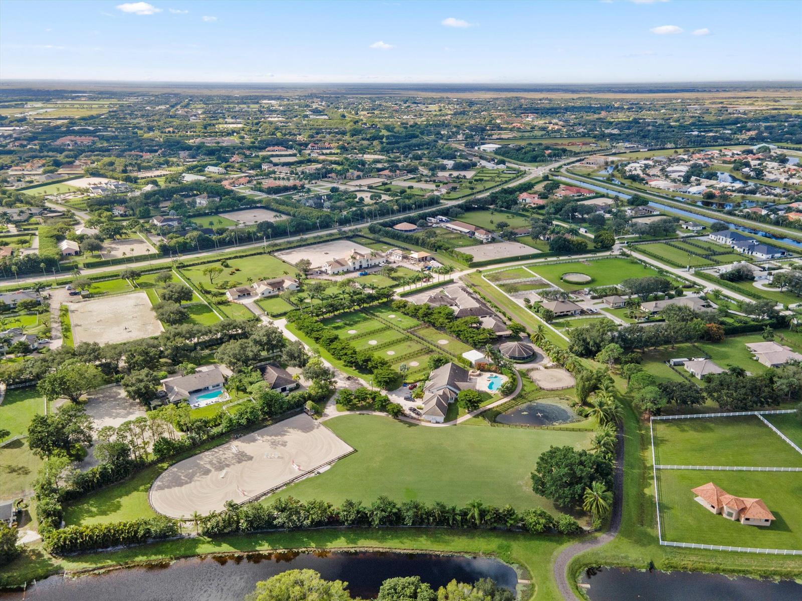 An aerial view shows a large residential estate with multiple buildings, paddocks, and riding arenas — 2389 King Terrace, Wellington FL 33414, WELLINGTON, FL