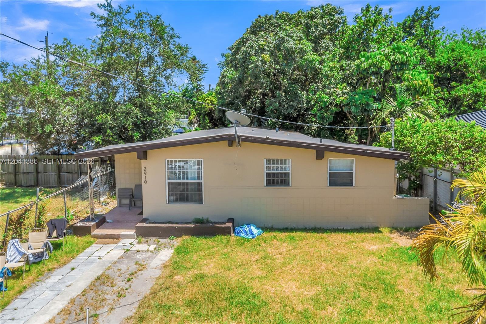 A single-story house with a beige exterior, a low-pitched roof, and a front yard — 2910 NW 47th St, Miami FL 33142, MIAMI, FL