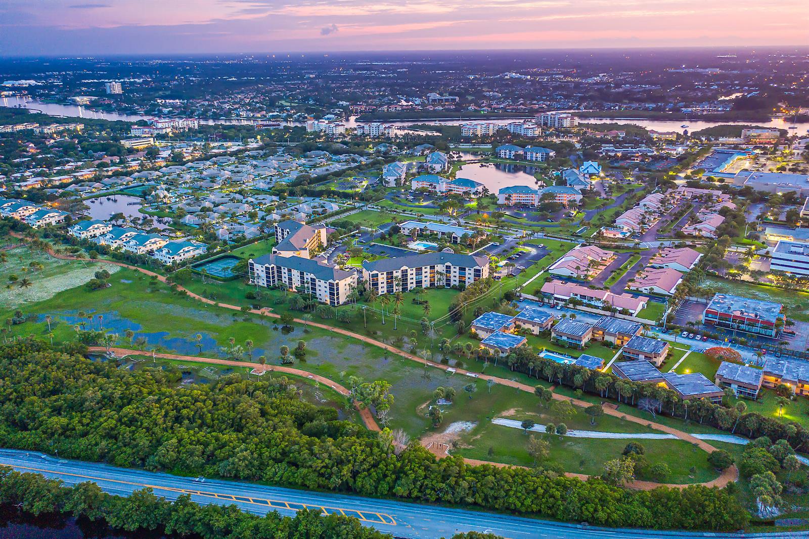 An aerial view shows a residential complex with multiple buildings, a pond, and surrounding greenery — 275 Palm Avenue # A201, Jupiter FL 33477, JUPITER, FL