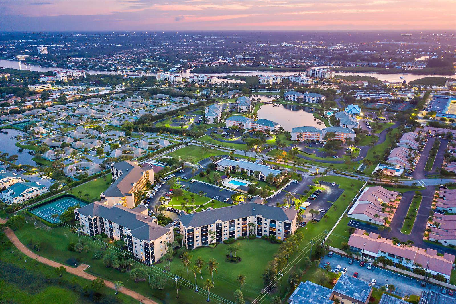 An aerial view of a residential complex with multi-story buildings, parking lots, and a lake — 275 Palm Avenue # A201, Jupiter FL 33477, JUPITER, FL