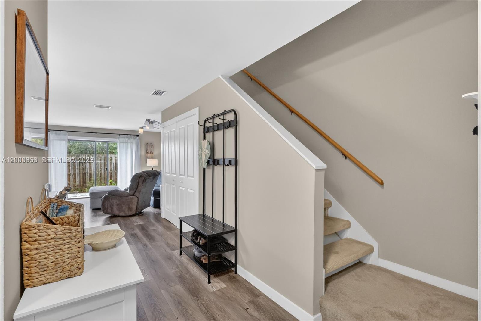 An entryway features a coat rack, stairs with carpeted steps, and wood-look flooring — 9425 S Ocean Dr # 67, Jensen Beach FL 34957, JENSEN BEACH, FL