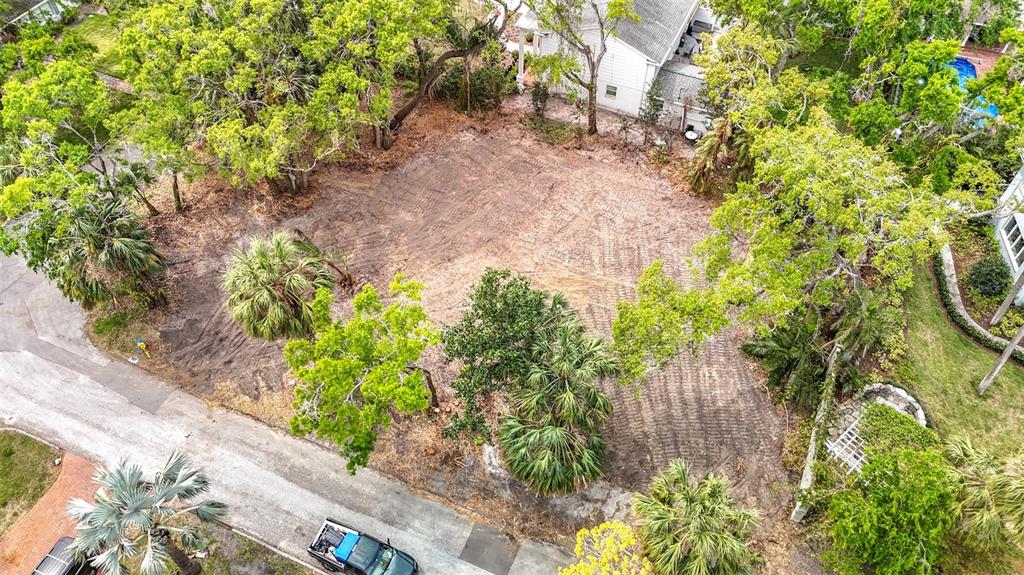 An aerial view shows a cleared, dirt residential lot surrounded by trees and neighboring houses — 4701 W CLEAR AVENUE, TAMPA, FL