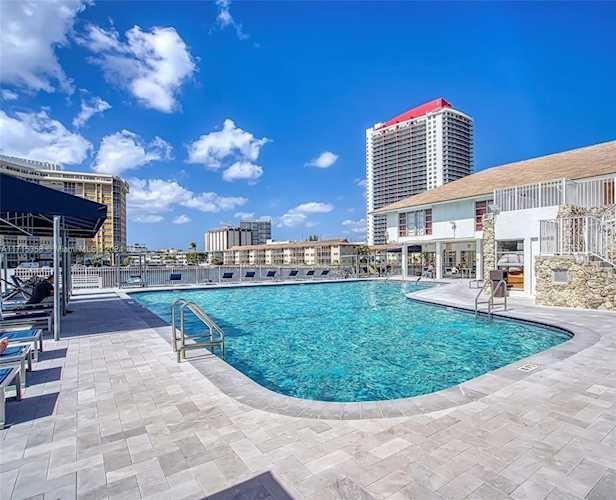 An outdoor swimming pool sits on a paved patio beside a multi-story building — 1833 S Ocean Drive # 1209, FL 33009, FL