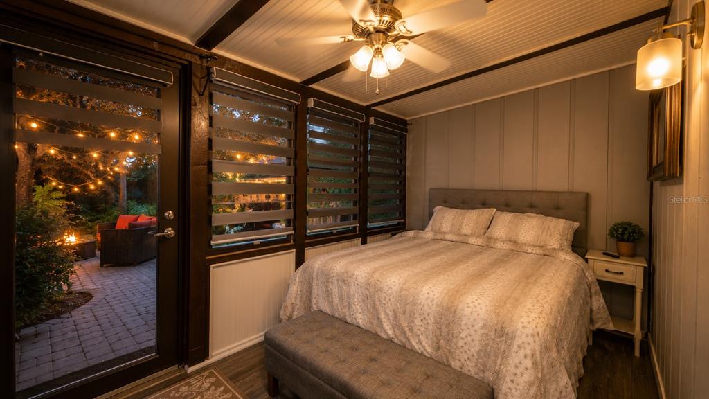 A bedroom with a bed, ceiling fan, and glass door opening to a lit patio — 3200 RIVER RANCH BOULEVARD UNIT 303, LAKE WALES, FL