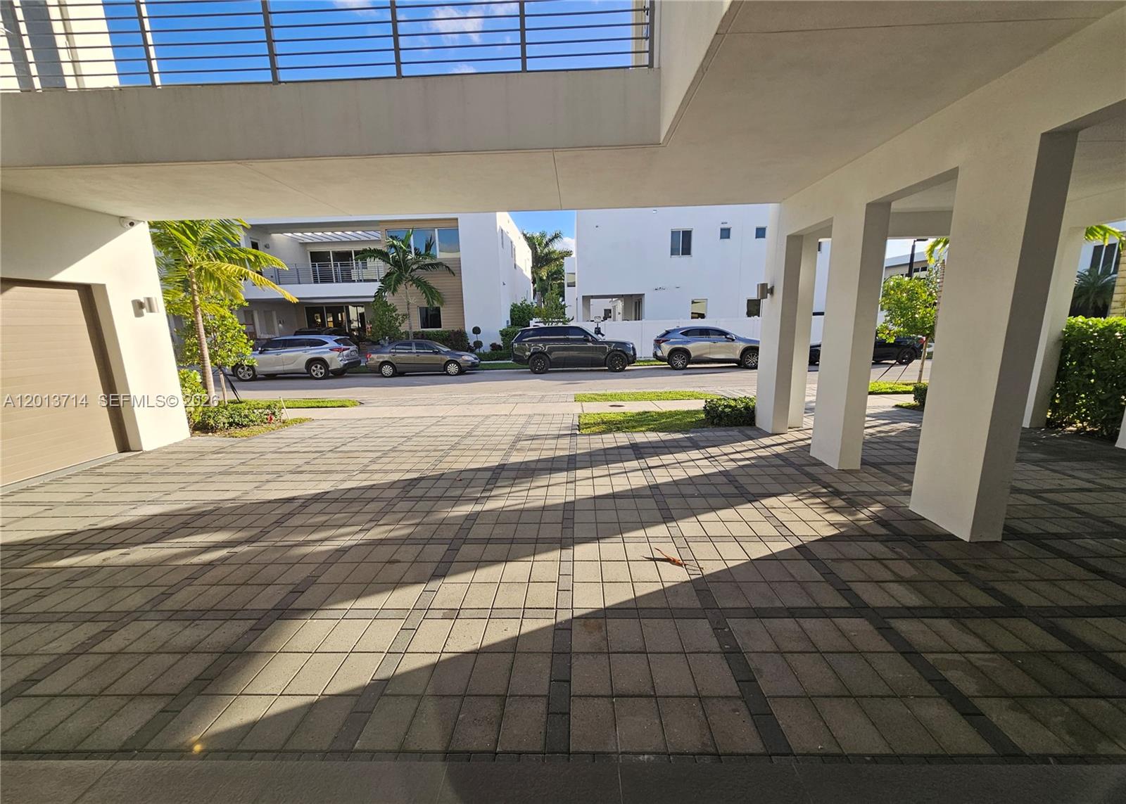 A paved driveway leads from a covered parking area toward a street with parked cars — 10289 NW 75th Ter # 10289, Doral FL 33178, DORAL, FL