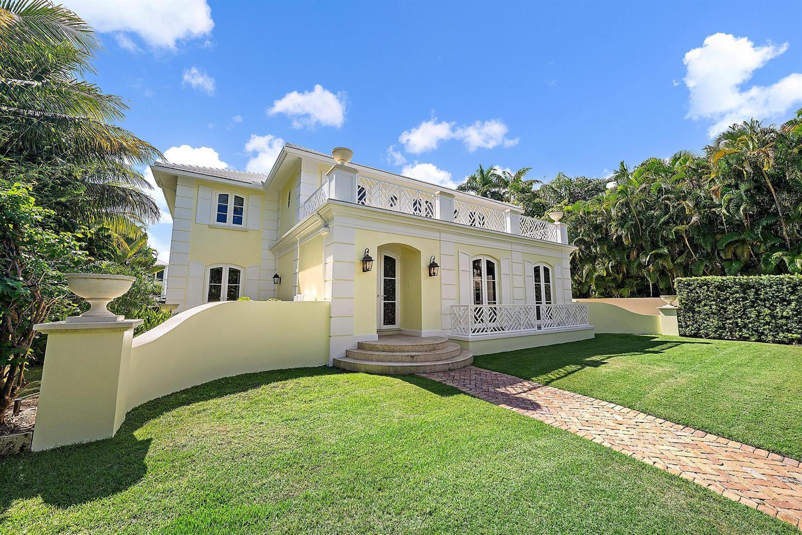 A two-story yellow house features a brick walkway, arched windows, and a white balcony railing — 210 Emerald Lane, Palm Beach FL 33480, PALM BEACH, FL