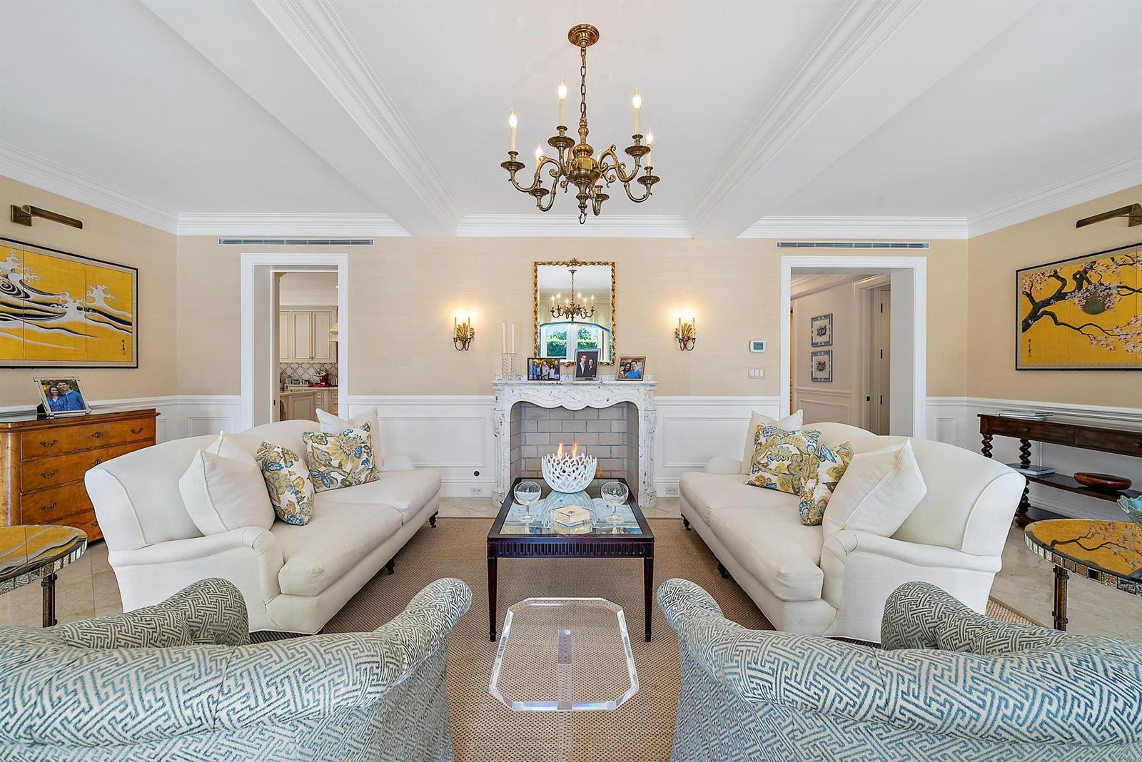 A formal living room features two white sofas, a fireplace, and a central chandelier — 210 Emerald Lane, Palm Beach FL 33480, PALM BEACH, FL