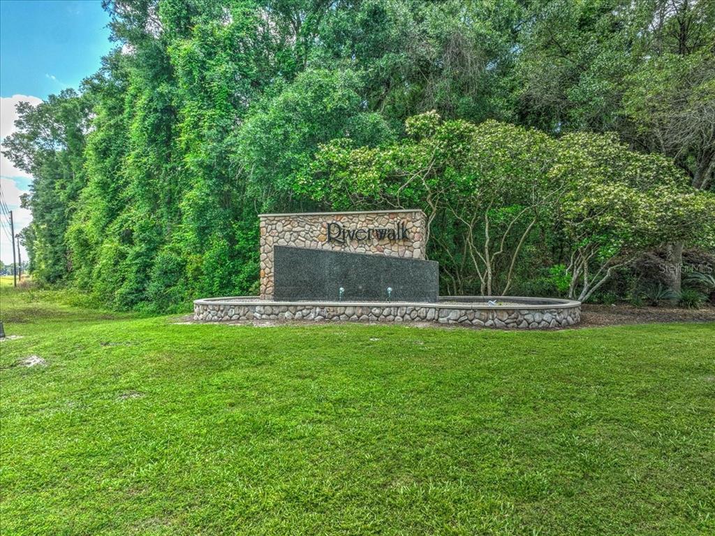 A stone and dark granite monument sign for Riverwalk sits on a grassy lawn — KATHERINE WAY, FANNING SPRINGS, FL