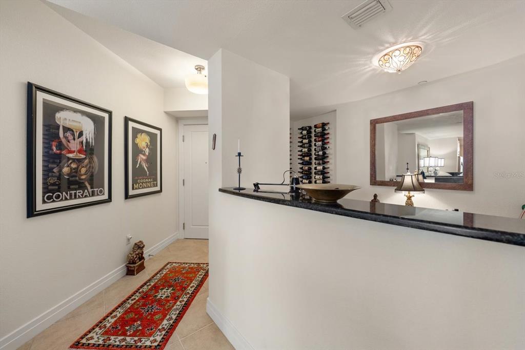 A hallway with framed posters, a red runner rug, and a built-in wine rack — 331 CLEVELAND ST UNIT #301, CLEARWATER, FL