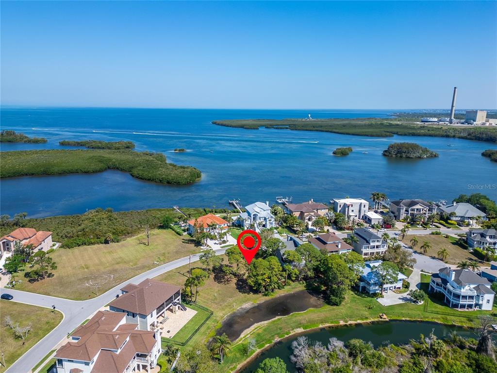 An aerial view shows a residential neighborhood with a red marker on a vacant lot — N POINTE ALEXIS DRIVE, TARPON SPRINGS, FL