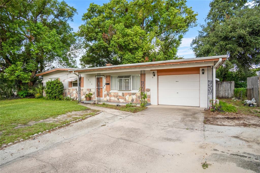 A single-story house with a stone facade, attached garage, and a concrete driveway — 1840 N POWERS DRIVE, ORLANDO, FL