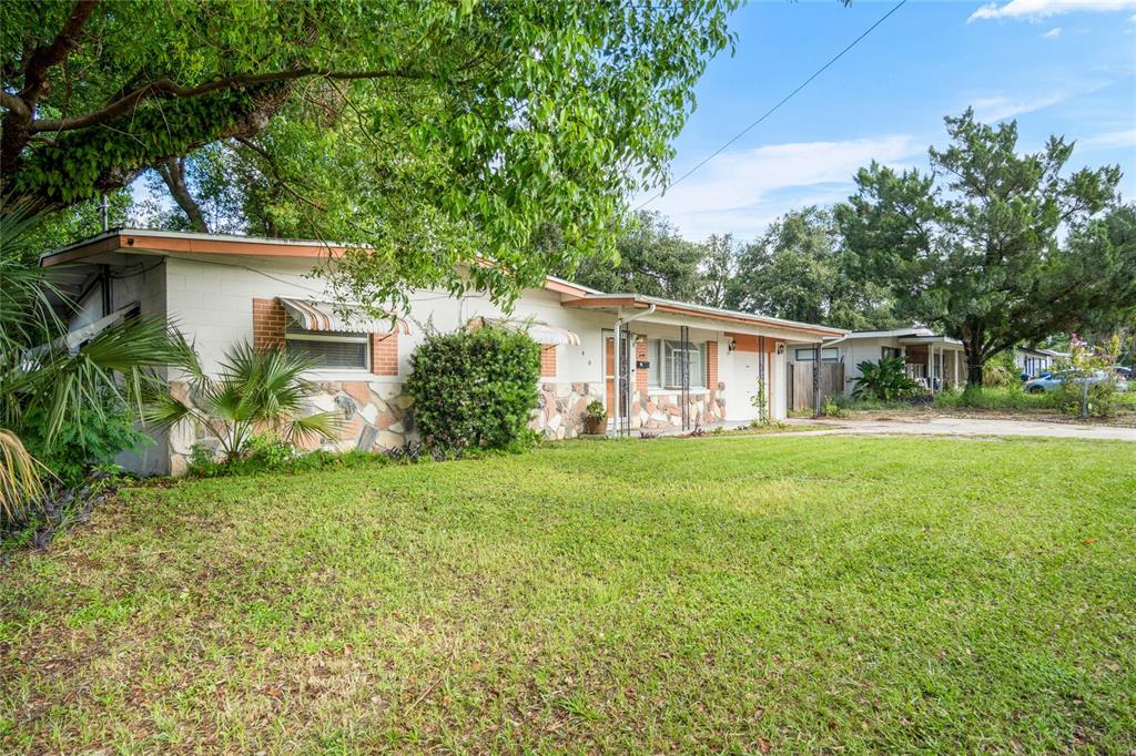 A single-story house with a stone and brick facade sits on a grassy lot — 1840 N POWERS DRIVE, ORLANDO, FL