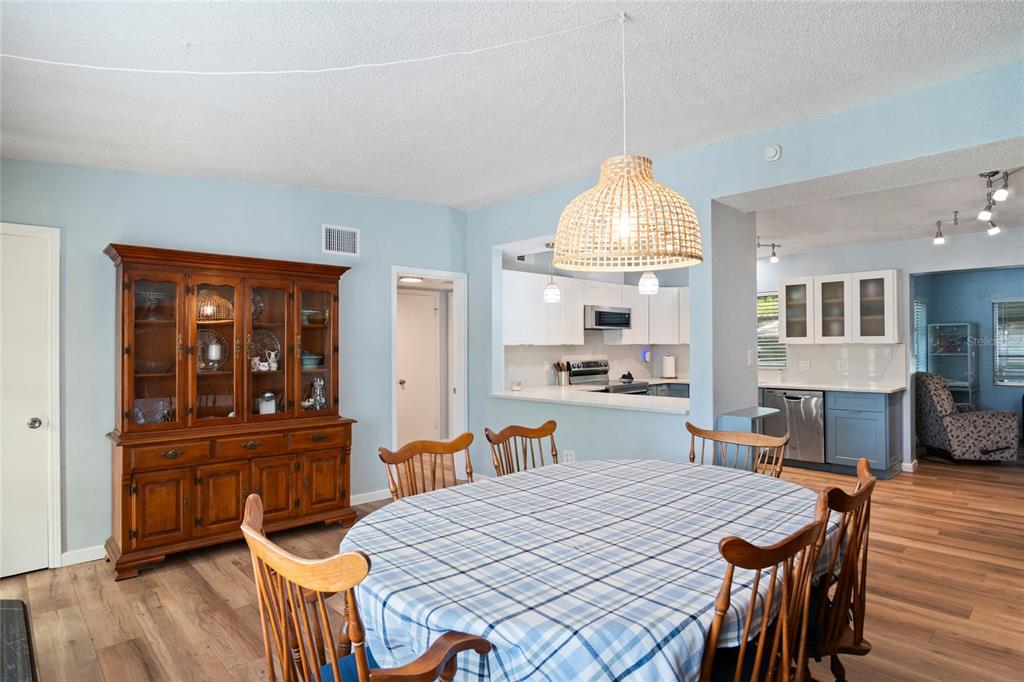 A dining area with a wooden hutch, round table, and open view into the kitchen — 1840 N POWERS DRIVE, ORLANDO, FL