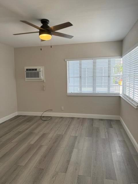 An empty room features light gray wood-look flooring, a ceiling fan, and a window unit — 112 Lake Avenue # 5, FL 33460, FL