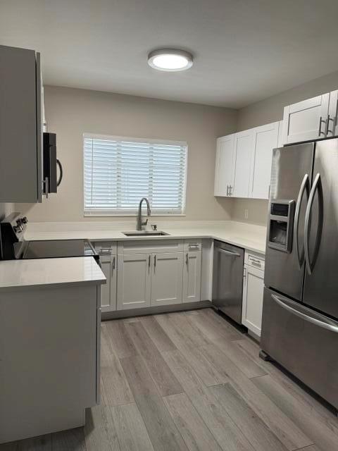 A kitchen features white cabinets, stainless steel appliances, and light wood-look flooring — 112 Lake Avenue # 5, FL 33460, FL