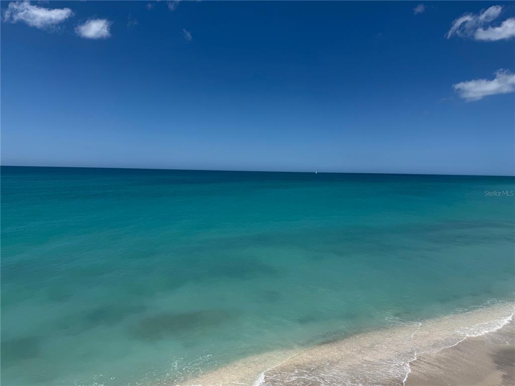 A high-angle view of a turquoise ocean meeting a sandy beach under a blue sky — 6780 MANASOTA KEY ROAD, ENGLEWOOD, FL