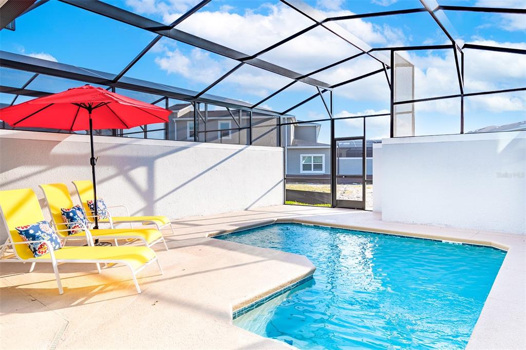 A screened-in patio features a swimming pool, yellow lounge chairs, and a red umbrella — 3011 PENELOPE LOOP, KISSIMMEE, FL