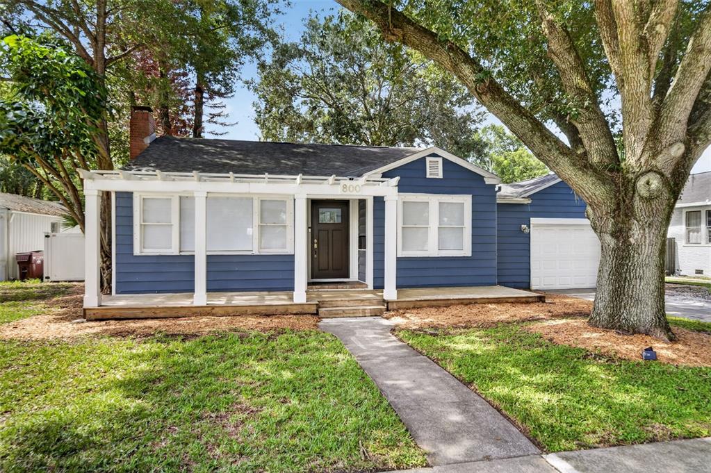 A blue single-story house with a wooden porch, pergola, and a large tree in front — 800 W SMITH STREET, ORLANDO, FL
