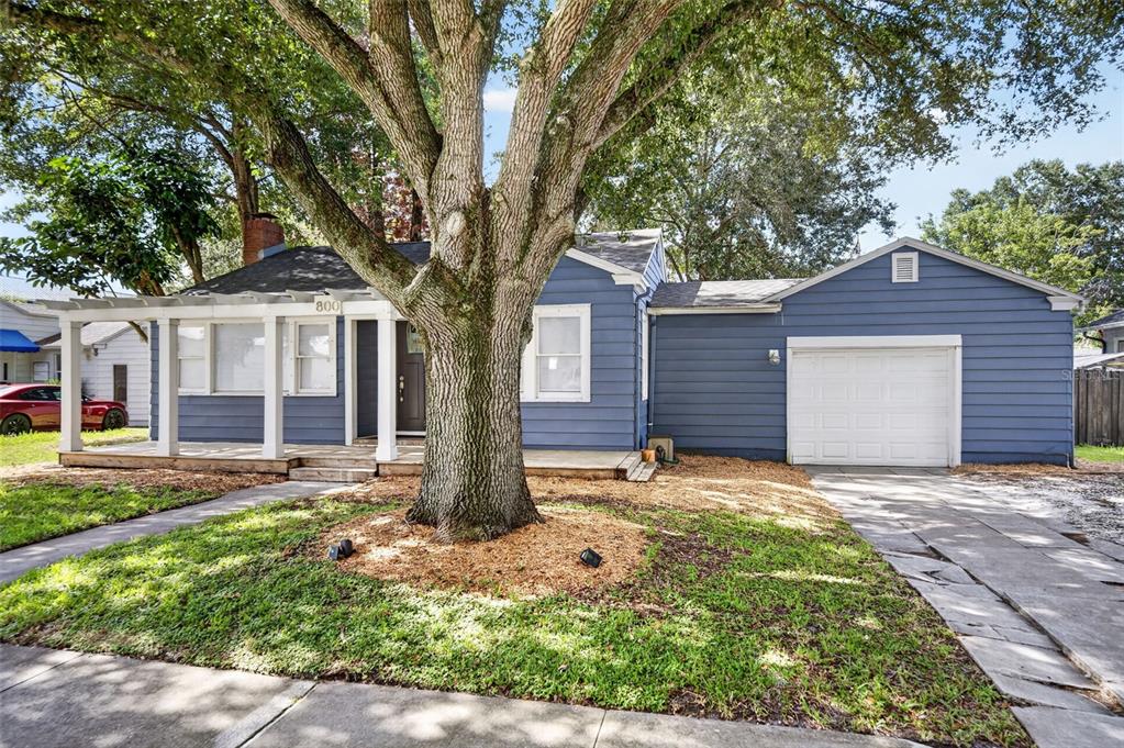 A blue single-story house with a white garage, front porch, and a large central tree — 800 W SMITH STREET, ORLANDO, FL