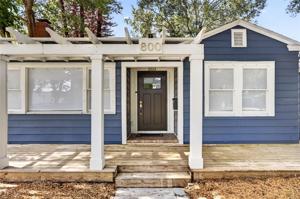 The exterior of a blue house features a wooden deck and a white pergola — 800 W SMITH STREET, ORLANDO, FL