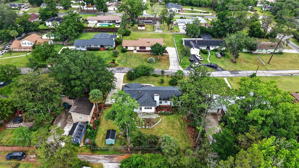 An aerial view shows a residential neighborhood with several houses, driveways, and mature trees — 550 SE 39TH TERRACE, OCALA, FL