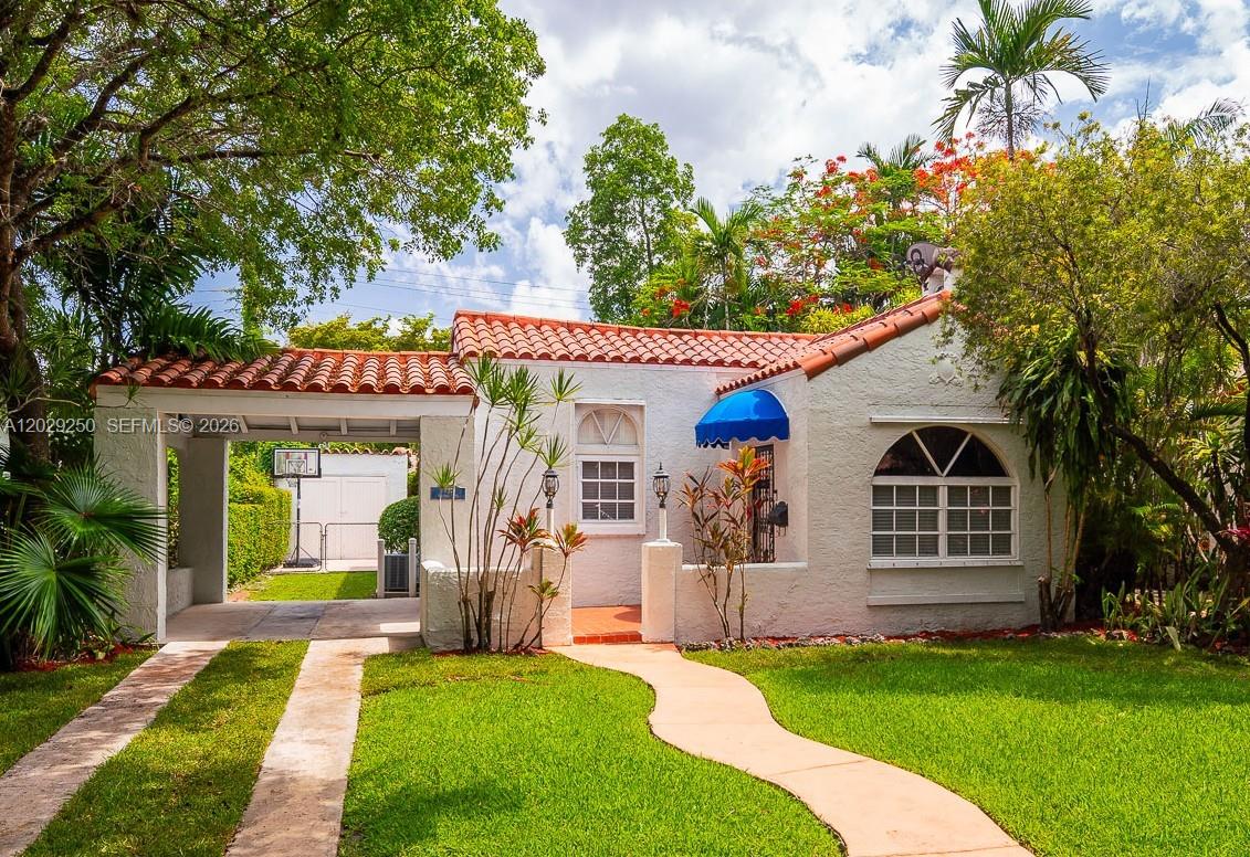 A white stucco house with a red tile roof, arched window, and attached carport — 732 Majorca Ave, Coral Gables FL 33134, CORAL GABLES, FL