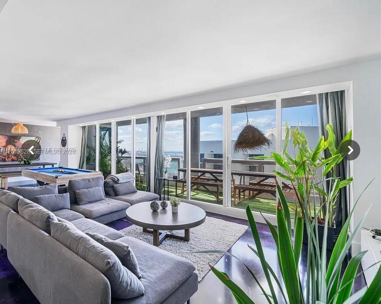 A living room features a grey sectional sofa, a pool table, and floor-to-ceiling glass doors — 1717 N Bayshore Dr # 3545, Miami FL 33132, MIAMI, FL