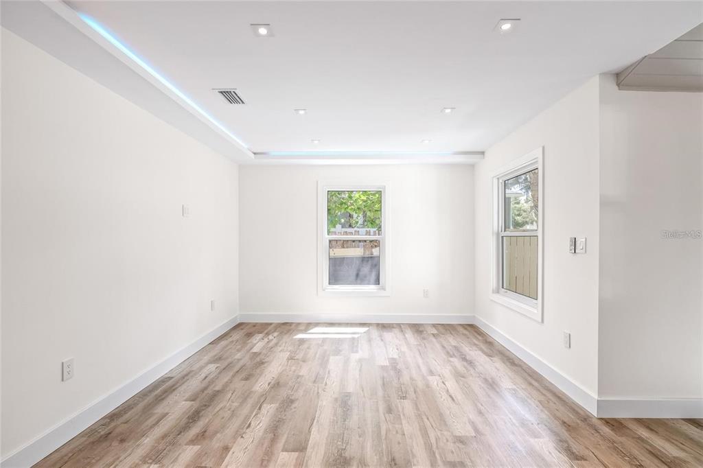 An empty room with white walls, recessed lighting, and light wood-look flooring — 6907 20TH STREET, TAMPA, FL