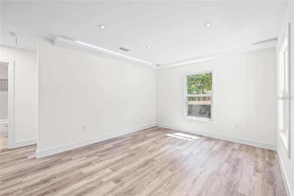 An empty bedroom with white walls, recessed lighting, and light wood-look flooring — 6907 20TH STREET, TAMPA, FL