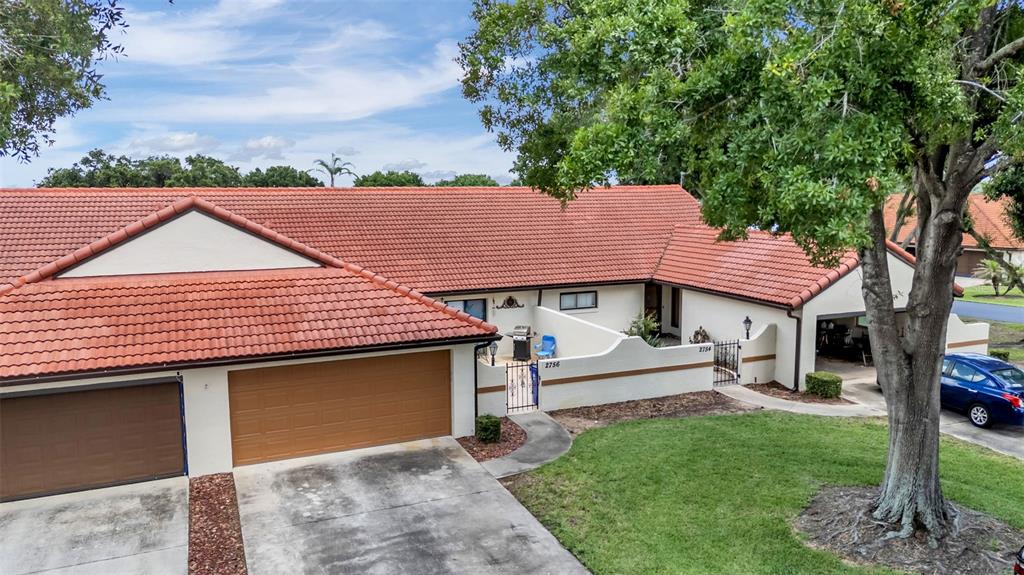 An exterior view of a single-story house with a red tile roof and garage — 2756 DEL CASA COURT UNIT 18, AVON PARK, FL