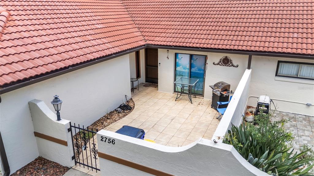An elevated view shows a tiled patio entrance with a metal gate and grill — 2756 DEL CASA COURT UNIT 18, AVON PARK, FL