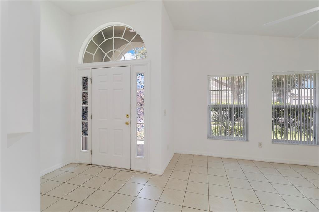 An entryway with white walls, tiled floors, a front door with sidelights, and arched transom — 11055 ROUSE RUN CIRCLE, ORLANDO, FL