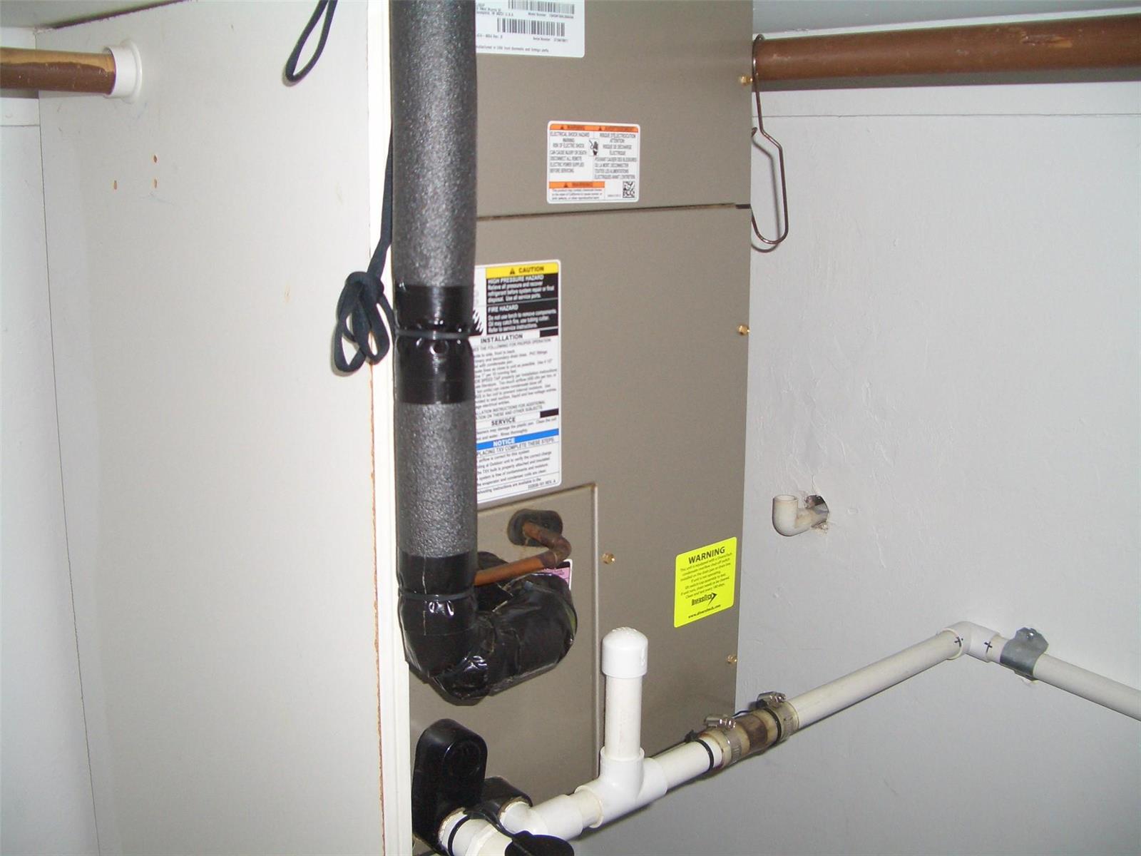 An indoor HVAC air handler unit is installed in a utility closet with white walls — 2737 NE 28th Street # 7w, Lighthouse Point FL 33064, LIGHTHOUSE POINT, FL