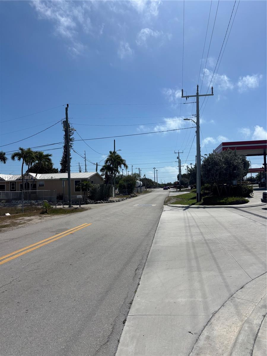 A paved road stretches into the distance past a gas station and residential properties — 319 Tuskegee Street, Marathon FL 33050, MARATHON, FL