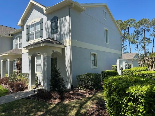 A two-story light blue house with a covered entryway and a manicured green hedge — 12405 CRUXBURY DRIVE, WINDERMERE, FL