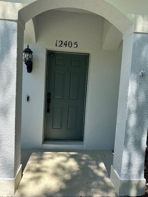 A covered entryway features a gray front door with the number 12405 above it — 12405 CRUXBURY DRIVE, WINDERMERE, FL
