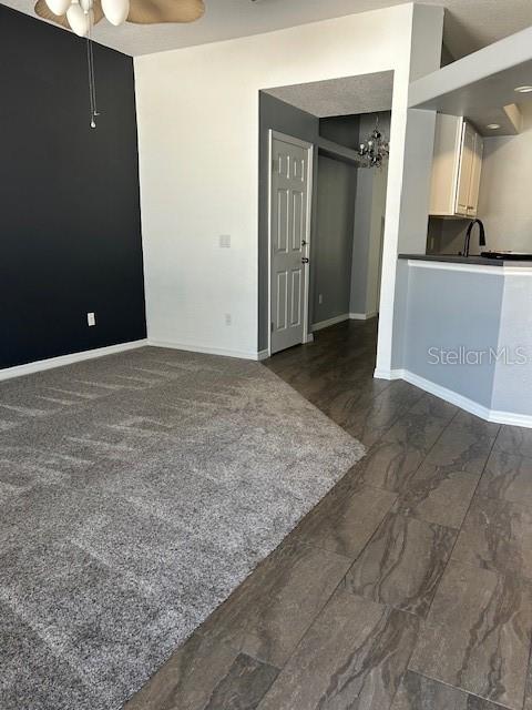 A living area features gray carpet, a dark accent wall, and adjacent tiled kitchen flooring — 12405 CRUXBURY DRIVE, WINDERMERE, FL