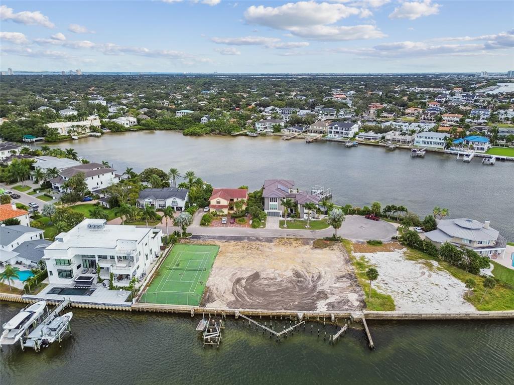 An aerial view shows a waterfront vacant lot featuring a tennis court and boat dock — 5031 W SAN MIGUEL STREET, TAMPA, FL