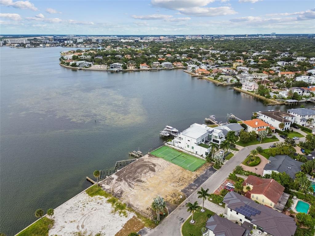 An aerial view shows a waterfront lot with a tennis court next to a house — 5031 W SAN MIGUEL STREET, TAMPA, FL