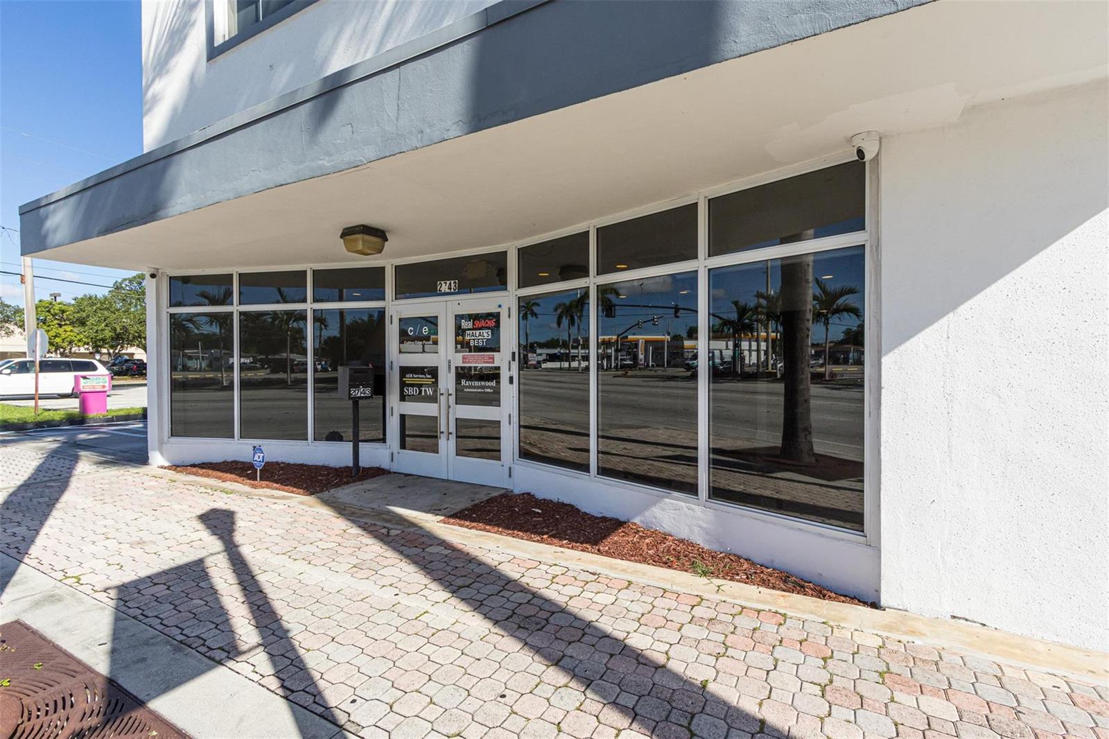 The exterior of a commercial building features a glass storefront with a paved walkway — 2743 Hollywood Boulevard, Hollywood FL 33020, HOLLYWOOD, FL