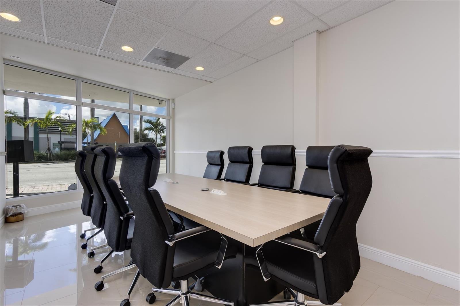 A conference room features a light wood table, black chairs, and large windows with exterior views — 2743 Hollywood Boulevard, Hollywood FL 33020, HOLLYWOOD, FL